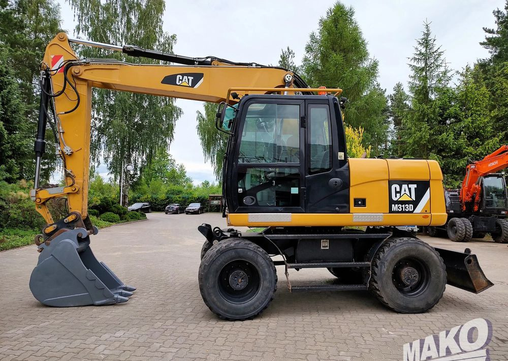 Caterpillar M313D - حفار ذو عجلات: صورة 1 Caterpillar M313D - حفار ذو عجلات: صورة 1