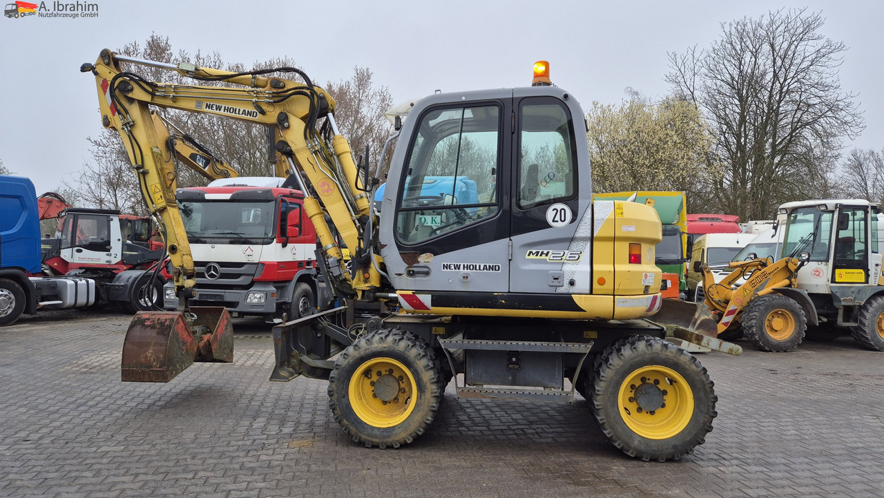 New Holland MH 2.6 Zustand gut, deutsche Maschine incl. Greifer und Dreservo - حفار ذو عجلات: صورة 1 New Holland MH 2.6 Zustand gut, deutsche Maschine incl. Greifer und Dreservo - حفار ذو عجلات: صورة 1