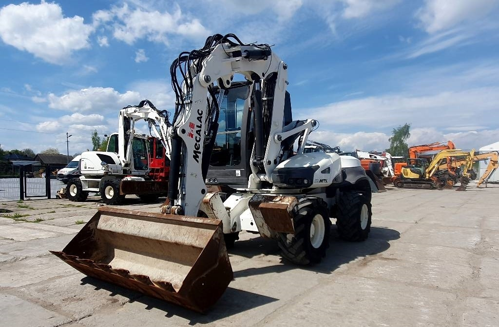Mecalac 12 M TX - حفار ذو عجلات: صورة 1 Mecalac 12 M TX - حفار ذو عجلات: صورة 1