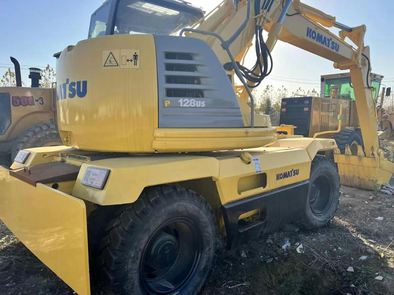 KOMATSU PC128US - حفار ذو عجلات: صورة 2 KOMATSU PC128US - حفار ذو عجلات: صورة 2