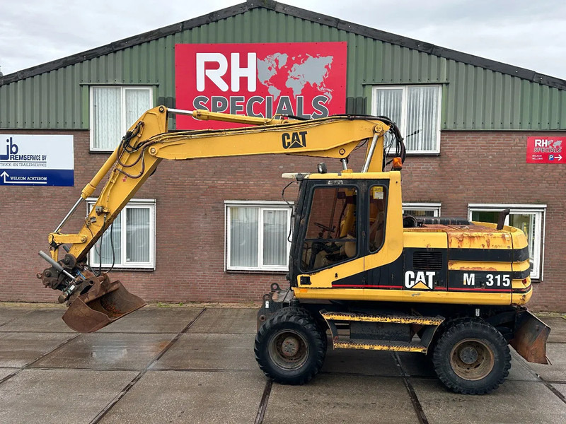 Caterpillar M315 +ROTO CE - حفار ذو عجلات: صورة 1 Caterpillar M315 +ROTO CE - حفار ذو عجلات: صورة 1